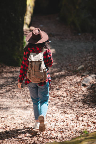 istock woman hiker with backpack walking by trail 1399411955