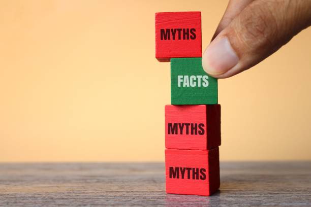 Facts vs myths concept. Hand pick wooden cube with text FACTS over MYTHS. Facts vs myths concept. Myths and Misconceptions stock pictures, royalty-free photos & images
