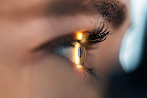 Closeup of a woman's eye looking at the sunset