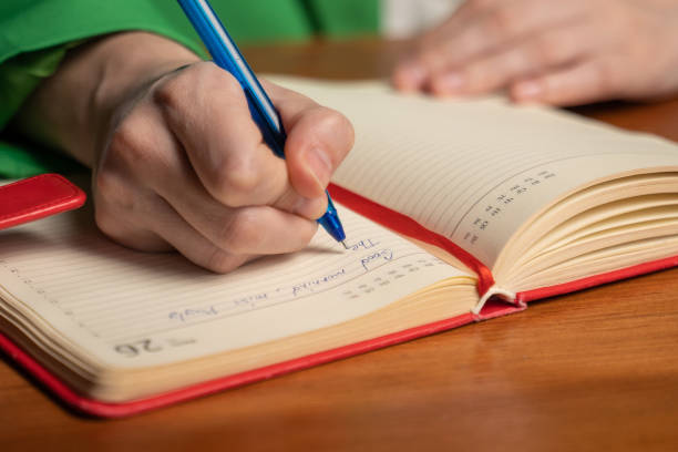 istock Woman writes schedule of work in diary sitting at table 1399420327