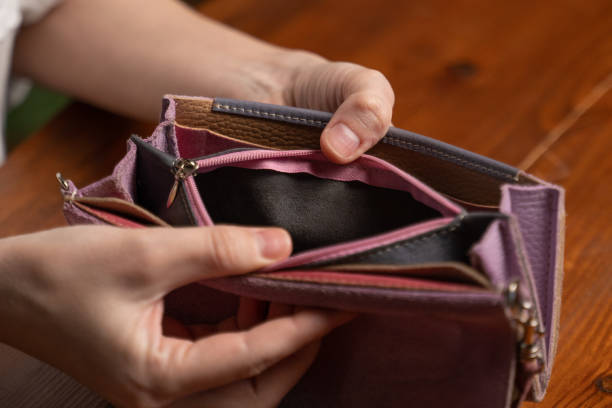 istock Woman opens empty wallet looking for money above table 1399420332