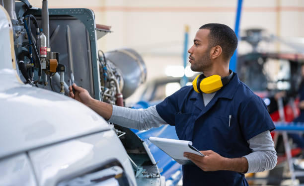 istock Male Aero Engineer With Clipboard Cheching On Helicopter In Hangar 1399420839