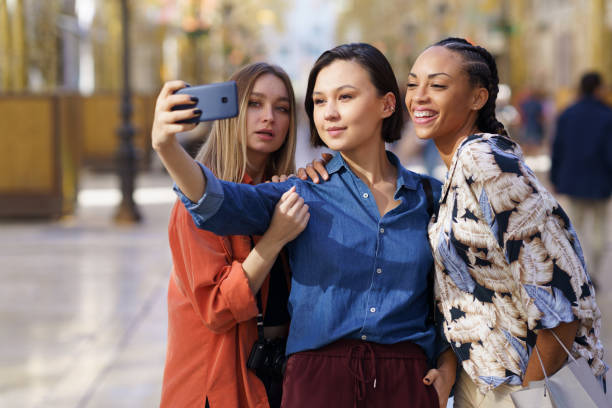 istock Trendy girlfriends taking selfie on street 1399422285