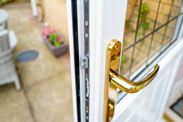 Shallow focus of the brass coloured door handle on a newly installed double glazed door Showing the leaded window, leading out onto a patio area. latch stock pictures, royalty-free photos & images