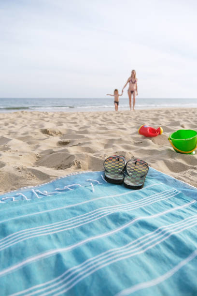istock Blanket with slippers and toys on beach 1399425279