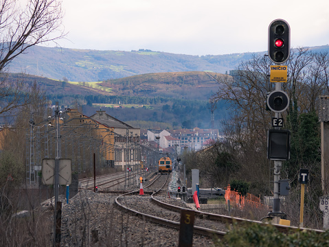 Monforte de Lemos, Lugo, Spain; 03-21-2022; Illuminated signal at the entrance to Monforte station indicating red (stop) during the electrification works and a workshop train working on the track