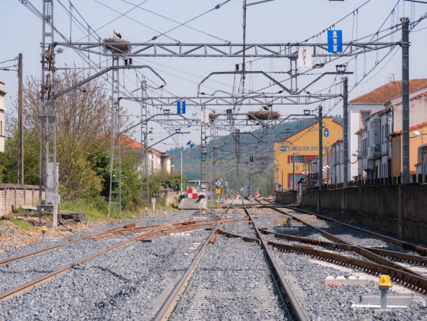 Train track under construction with a red and white sign preventing traffic at Monforte station towards Lugo under the wires of the catenary and the recently installed ballast