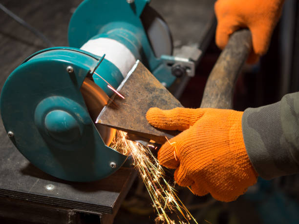 istock man sharpening an ax blade on a grinder 1399428816