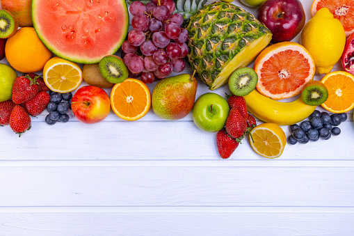 Assorted fresh fruits for healthy eating. Watermelon, pineapple, apple, pear, strawberry, kiwi, lemon, orange, grape, blueberry, pomegranate, mango, banana.