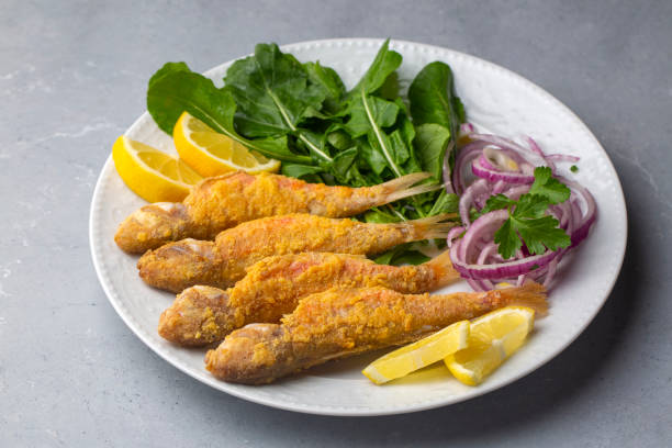 Plate of fried small fish red mullet and lemon