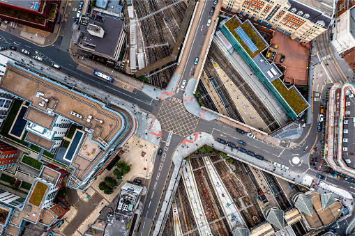 An aerial view directly above an urban metropolis with crossroad street junction over busy railway lines