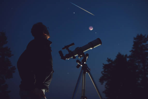 silueta de un hombre, telescopio, estrellas, planetas y estrella fugaz bajo el cielo nocturno. - lluvia de meteoritos fotografías e imágenes de stock