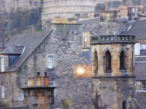 Crowding the base of Edinburgh Castle are houses and picturesque towers…just starting to light up at dusk.
