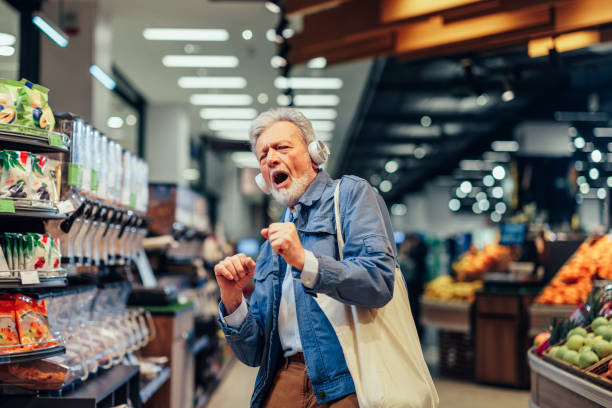 Senior man having fun while shopping in supermarket stock photo