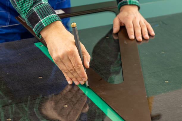 istock cutting glass, Glazier manually cuts the glass to size using specialized tools 1399439328