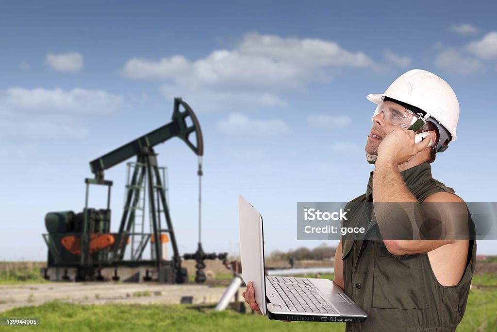 Operário Petrolífero com computador portátil e telefone - Royalty-free A usar um telefone Foto de stock