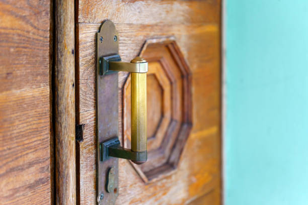 Old copper handle with scuffs on the wooden door.