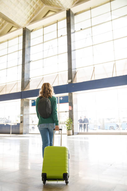 istock Woman walking through a railway station, dragging her suitcase, going home after a trip 1399441997