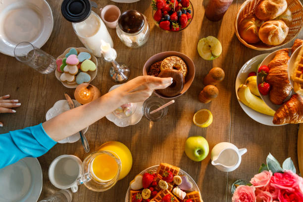 istock Female hand reaching for a chocolate doughnut served on a dining table 1399442589