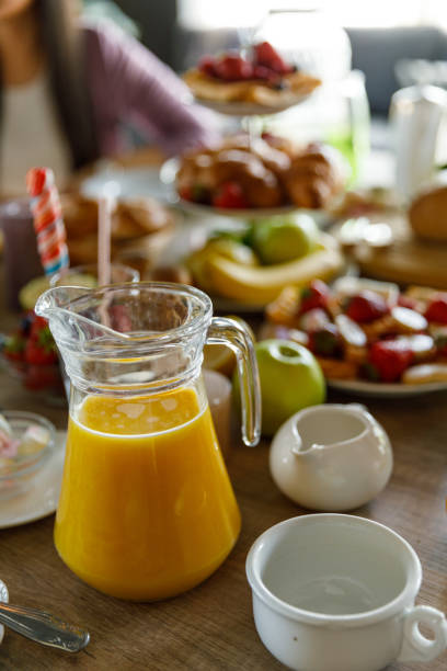 istock Fresh orange juice in a glass pitcher served on a table during breakfast 1399442619
