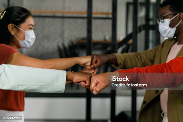 Cut Out Shot Of Business People Fist Bumping Each Other Stock Photo - Download Image Now