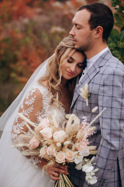 istock Wedding couple with bouquet with roses and spikelets .Boho style in brides hands 1399443457