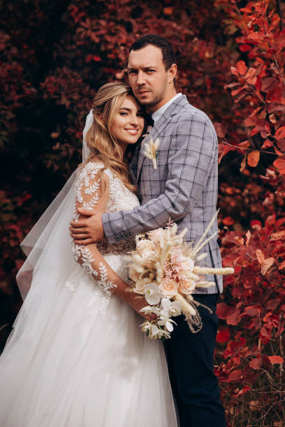 istock Happy bride and groom with boho bouquet in autumn 1399443469