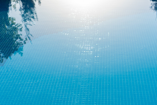 Clear blue water in the pool under the rays of the sun.