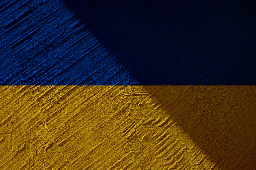 Ukrainian state national flag. Texture concrete grunge wall in yellow-blue color. State symbol of Ukraine and Ukrainians. Ukrainian flag on a concrete wall background