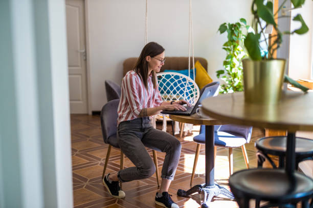 istock Young woman using a laptop at home 1399445974