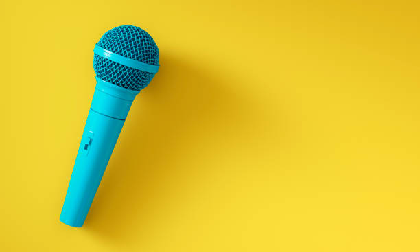 Blue microphone isolated on yellow background stock photo