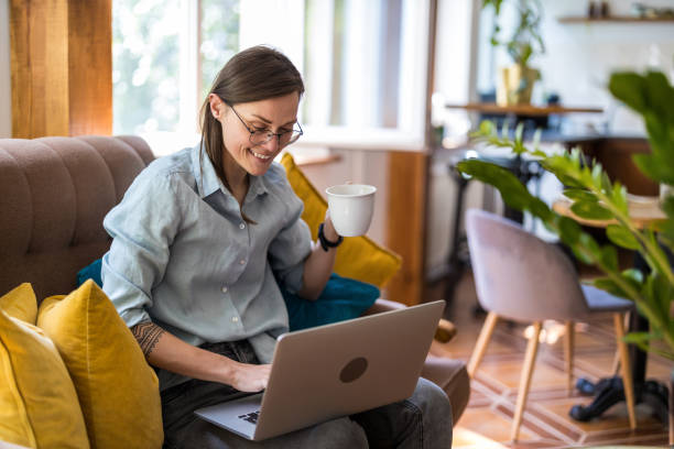 istock Young woman using a laptop at home 1399446932