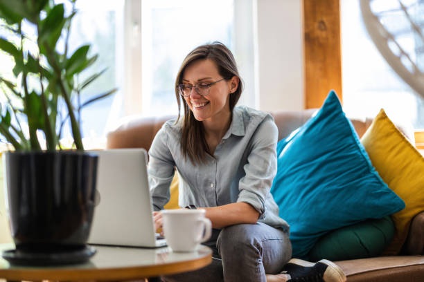Young woman using a laptop at home stock photo