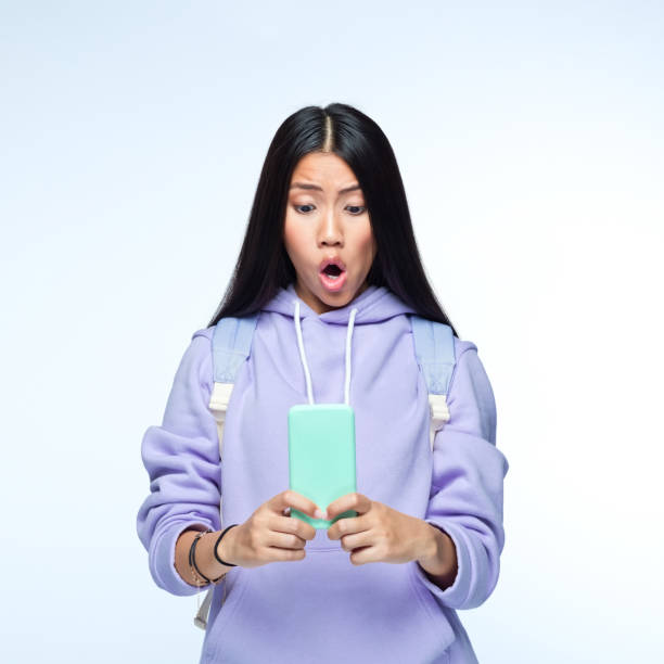 istock Woman using mobile phone against gray background 1399447124