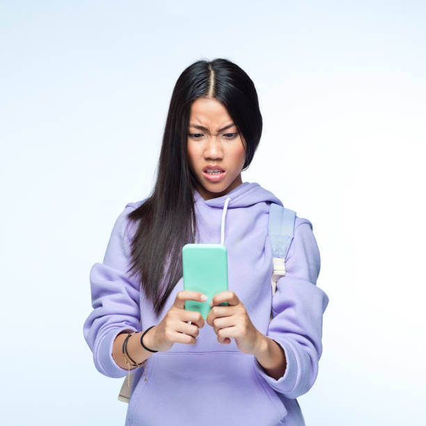 istock Woman using mobile phone against gray background 1399447150