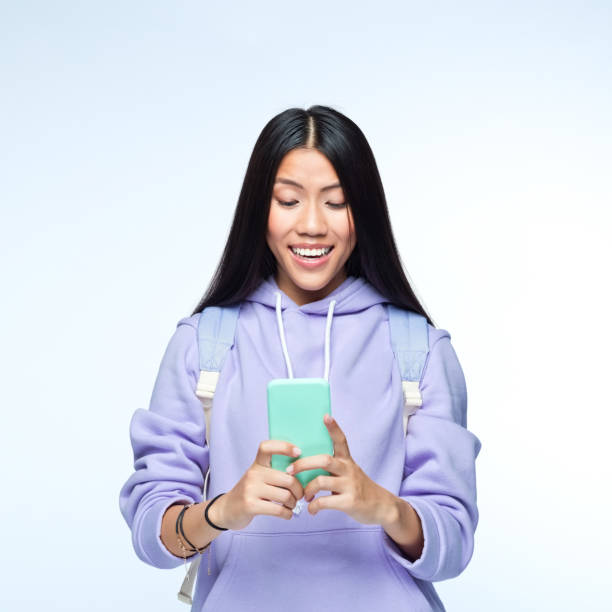 istock Woman using mobile phone against gray background 1399447192