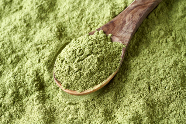 istock Green barley grass powder on a wooden spoon 1399448796