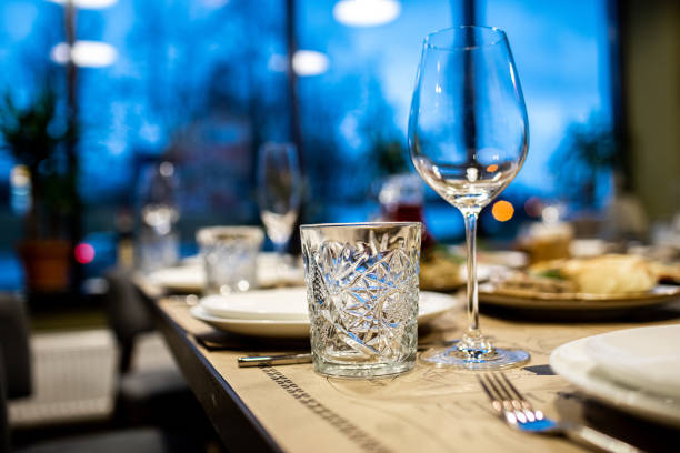 istock Empty glass set in restaurant. wedding, decor, celebration, holiday concept - romantic table setting with white tablecloth, plates, crystal glasses 1399461633