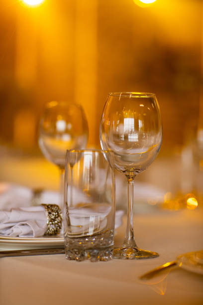 istock Empty glass set in restaurant. wedding, decor, celebration, holiday concept - romantic table setting with white tablecloth, plates, crystal glasses 1399461641
