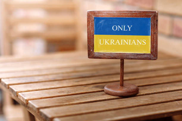 カフェのゲストのためのテキストとレストランの木製のテーブル上の空の木製の予約プレートは、ウクライナの青と黄色の色の旗を持つウクライナの人々だけ - native american reservation wildlife reserve restaurant dinner ストックフォトと画像