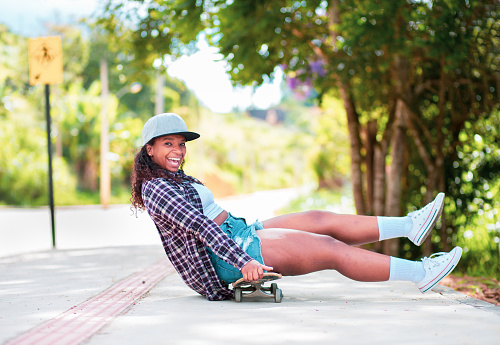 Young black woman happy and having fun on a skateboard on the street.