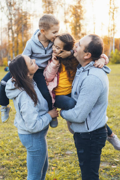 istock Parents with two children spending time together and having fun while walking through the park in the fall. Smiling happy child. Happy family together. 1399471312