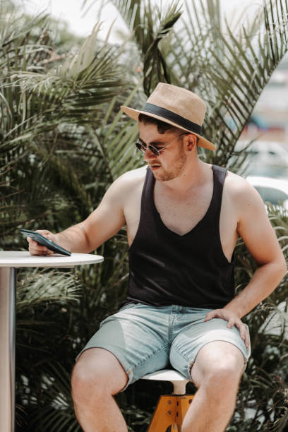 istock Tourist sitting on a bar stool with a mobile phone 1399477071