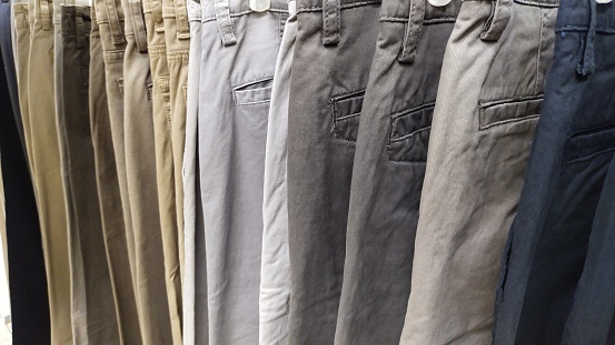 Stacks of gray jeans neatly arranged on a mall shelf. Suitable for fish pants and other clothing materials, etc