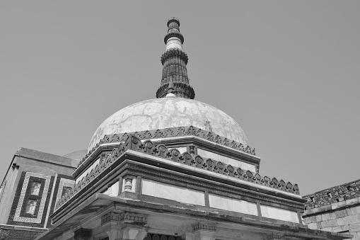 The tomb of Imam Zamin is a mausoleum housing the remains of Muhammad Ali (popularly known as Imam Zamin), an Islamic cleric of the 16th century. It is located at the Qutub Minar complex, Delhi, in India.\n\nA shot from the ground capturing the two monuments.