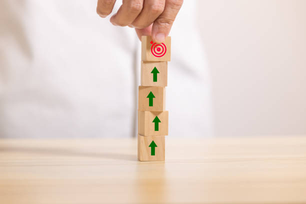 istock hand stack wooden blocks set to step with icon arrow to target. Concept for growth business and targeting. 1399491908