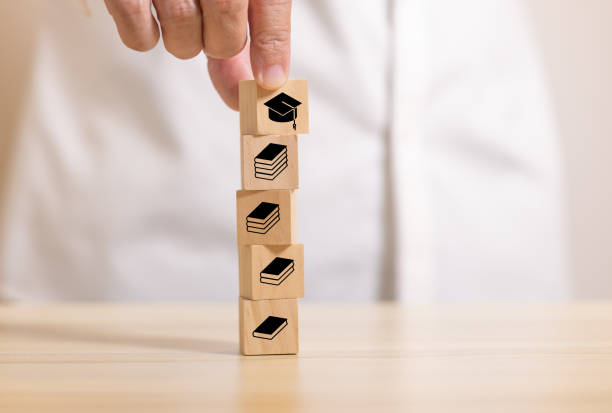 istock hand stack wooden blocks with book icon to graduate icon. Concept for learning and education. 1399491909