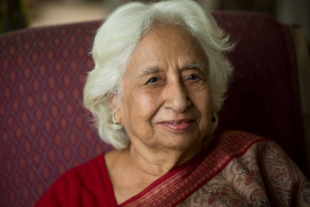 istock Old woman smiling while sitting on chair 1399497581
