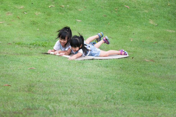 A boy shows his sister the ladybug in his hand