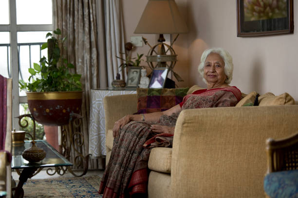 istock Happy old woman sitting on sofa at home 1399499754